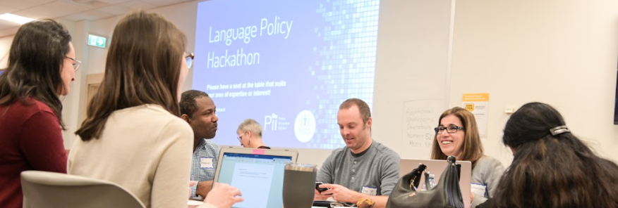 Group of people at a table during the "Language Policy Hackathon".
