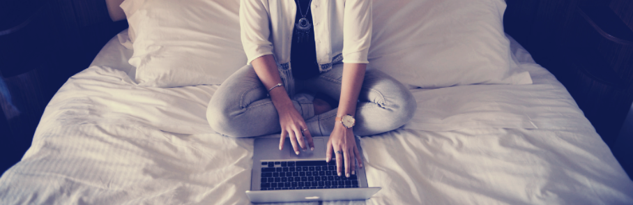 Woman with computer in bed.