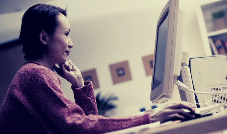 Woman with computer at desk.